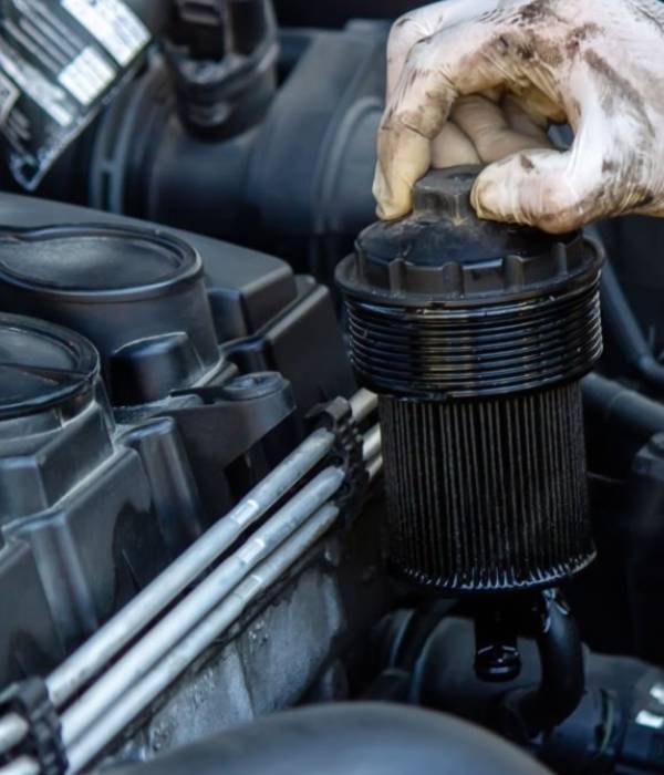 Mechanic removing an engine oil filter during vehicle maintenance